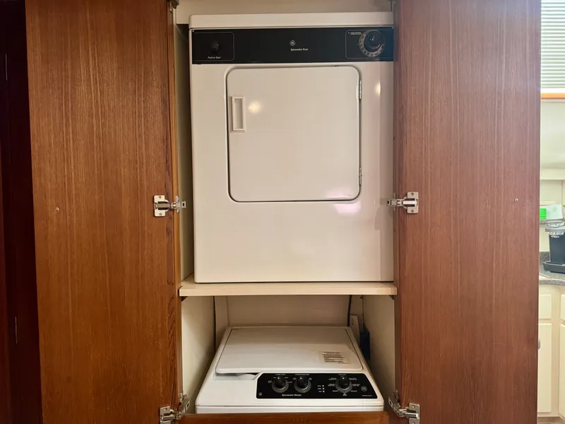 Slide: The Image of A washer and dryer set is installed in a wooden cabinet, with a washer below and a dryer above. - 43