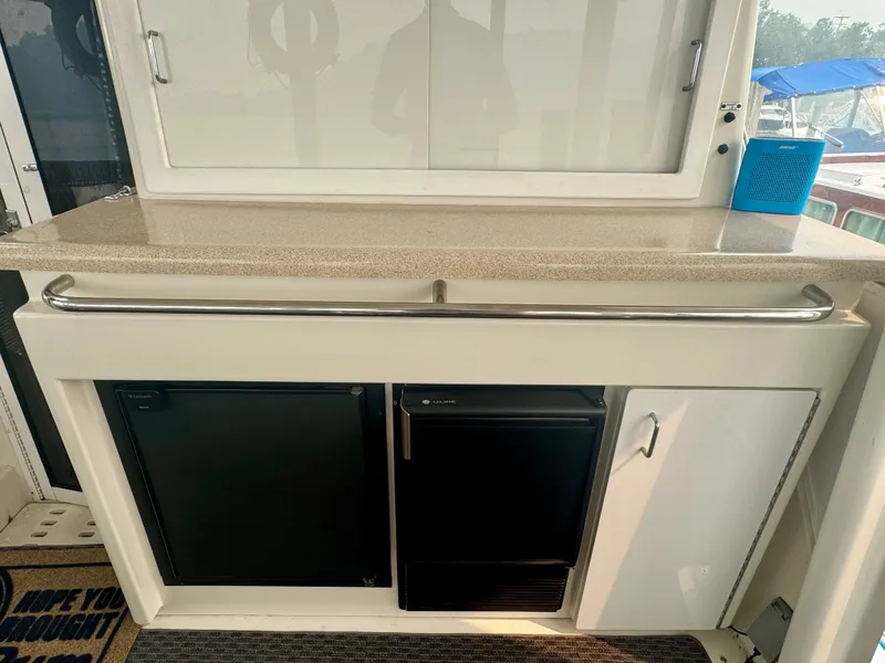 Slide: The Image of The yacht's galley features two black refrigerators and a countertop with a railing. - 22