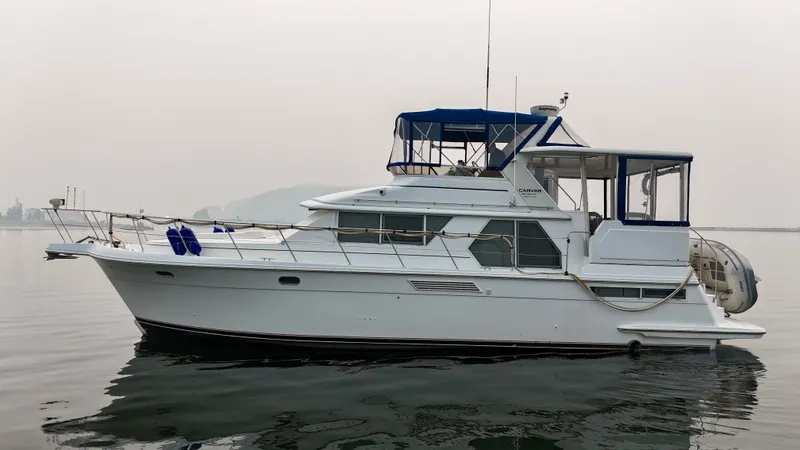 Slide: The Image of A white 1997 Carver 445 Aft Cabin Motor Yacht floats calmly on the water. - 9