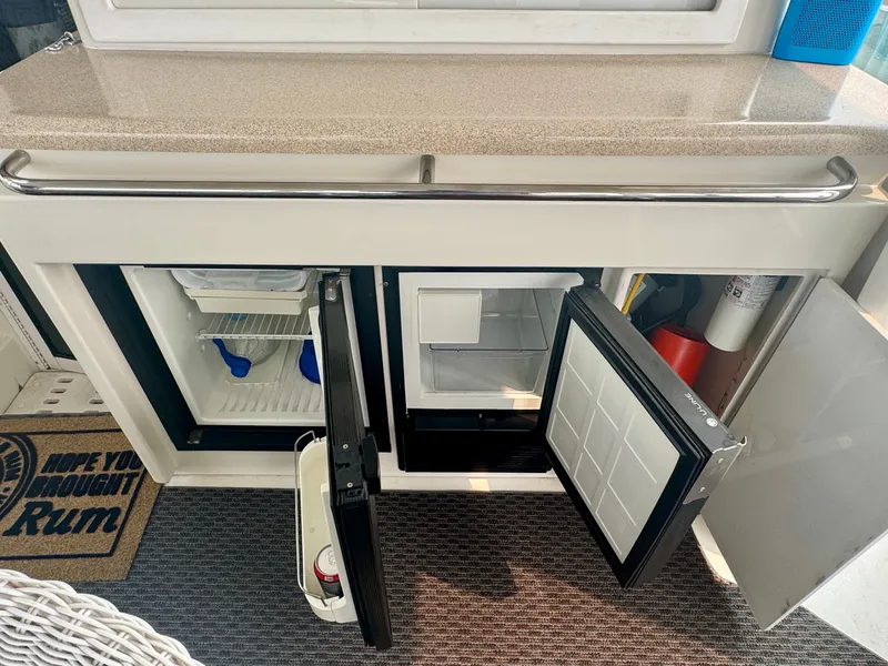 Slide: The Image of The 1997 Carver 445 Aft Cabin Motor Yacht features an open minibar with a fridge and storage space. - 23
