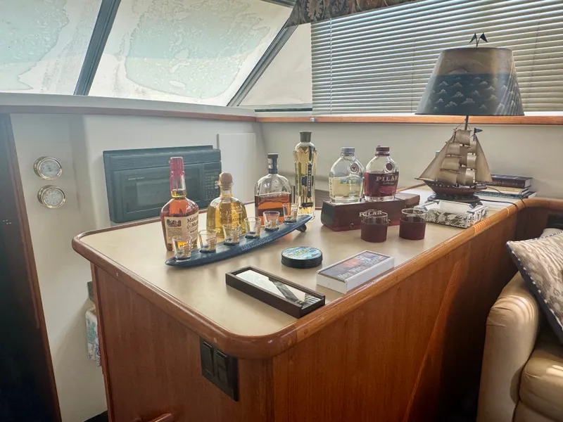Slide: The Image of A cozy interior with a bar displaying various liquor bottles and a model ship. - 35