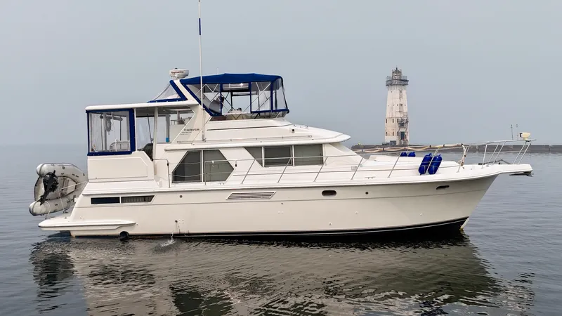 Slide: The Image of 1997 Carver 445 Aft Cabin Motor Yacht near a lighthouse on calm water. - 5