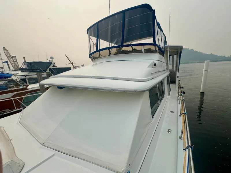 Slide: The Image of The 1997 Carver 445 Aft Cabin Motor Yacht is docked in a calm marina. - 20