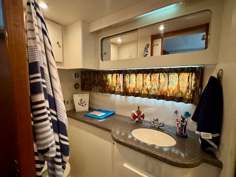 Slide: The Image of The image shows a yacht bathroom with a sink, mirror, and decorative curtains. - 48