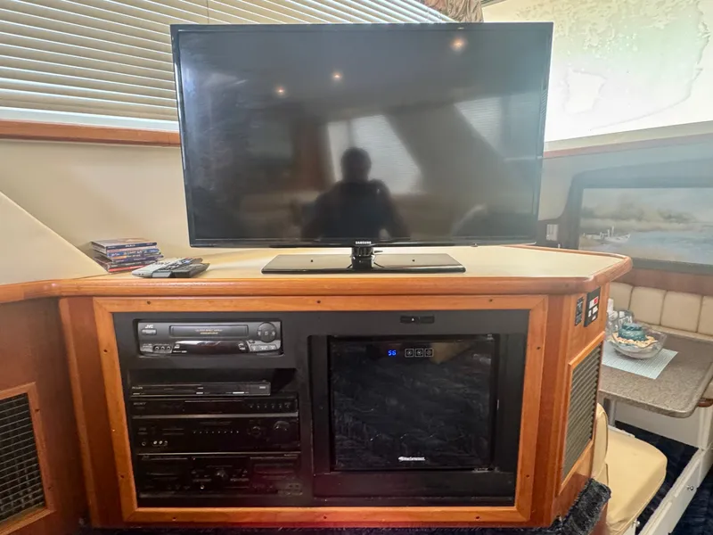 Slide: The Image of The yacht interior features a TV on a wooden cabinet with entertainment electronics. - 34
