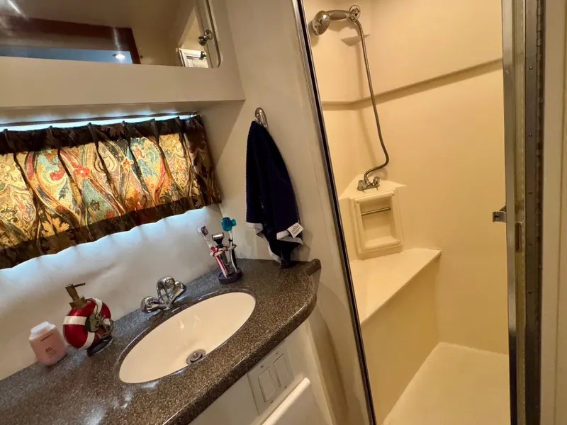 Slide: The Image of The image shows a bathroom with a sink, mirror, and shower in a yacht. - 49