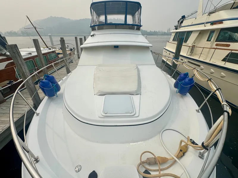 Slide: The Image of 1997 Carver 445 Aft Cabin Motor Yacht at dock with spacious foredeck and blue cover. - 19