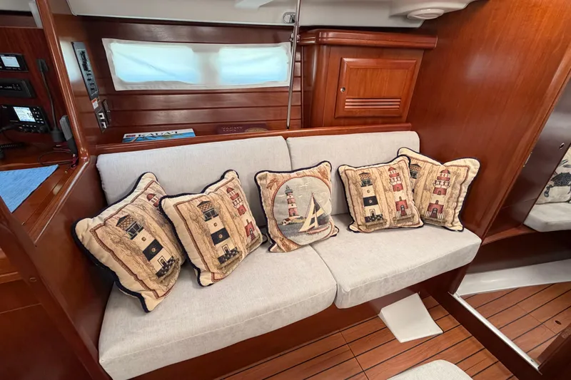 Slide: The Image of Interior of 2006 Beneteau 423 yacht with nautical-themed cushions on a wooden bench. - 41