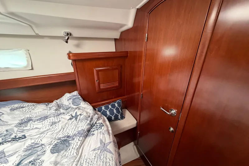 Slide: The Image of Cozy cabin interior of 2006 Beneteau 423 yacht with wooden finish and nautical bedding. - 49