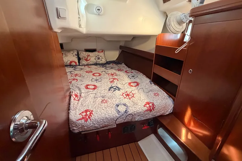 Slide: The Image of Cozy cabin interior of 2006 Beneteau 423 sailboat with nautical-themed bedding. - 49
