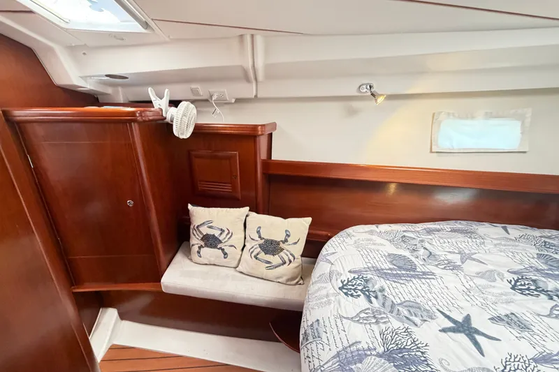Slide: The Image of Cozy cabin interior of 2006 Beneteau 423 yacht with nautical-themed bedding and cushions. - 47