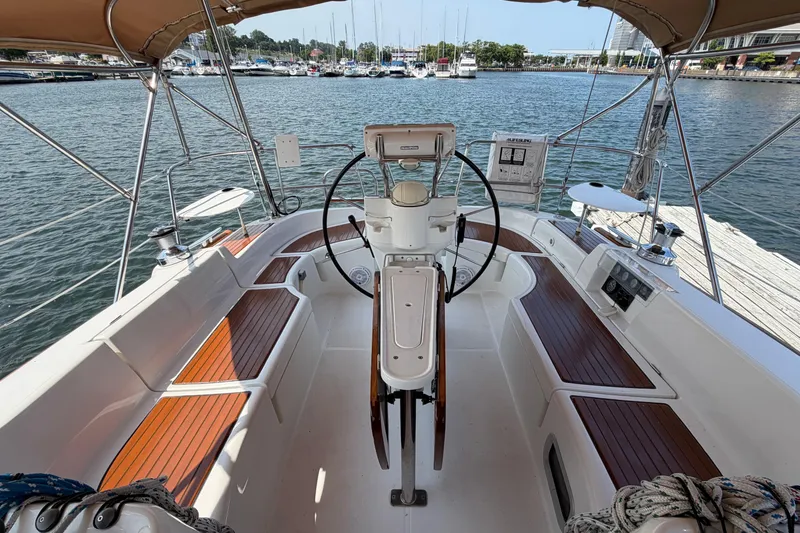 Slide: The Image of Cockpit of 2006 Beneteau 423 sailboat with wooden seating and steering wheel. - 25