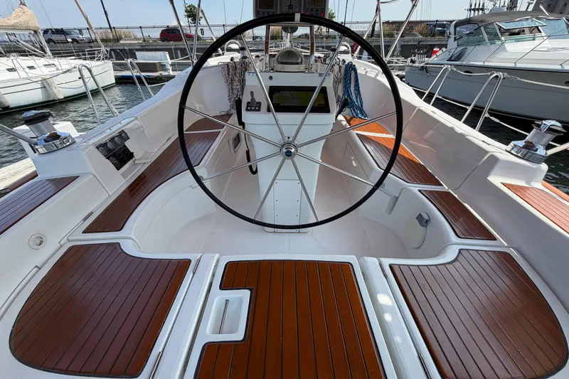 Slide: The Image of Cockpit of a 2006 Beneteau 423 sailboat with wooden seating and steering wheel. - 8
