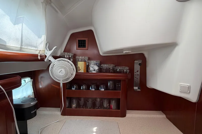 Slide: The Image of Interior of a 2006 Beneteau 423 yacht with shelves, fan, and kitchen items. - 34