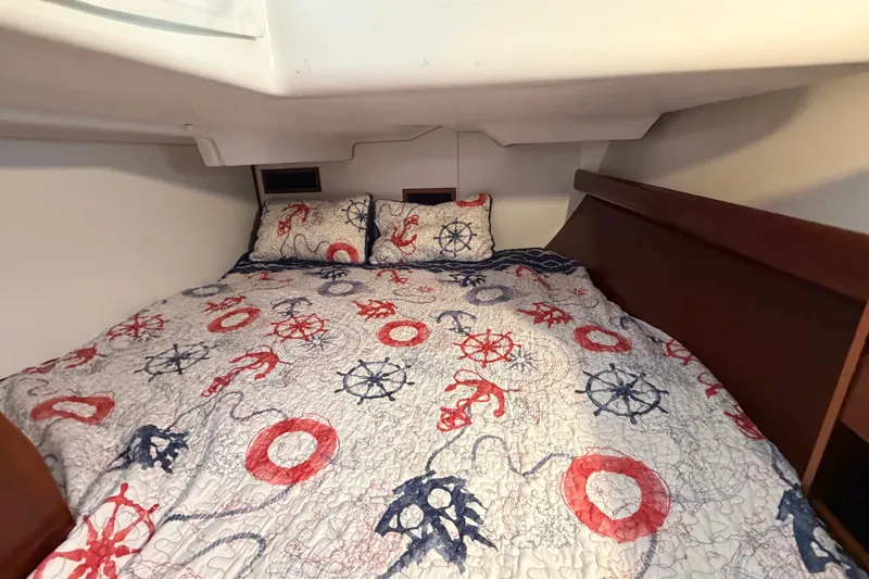 Slide: The Image of Cozy cabin bed in 2006 Beneteau 423 sailboat with nautical-themed bedding. - 51