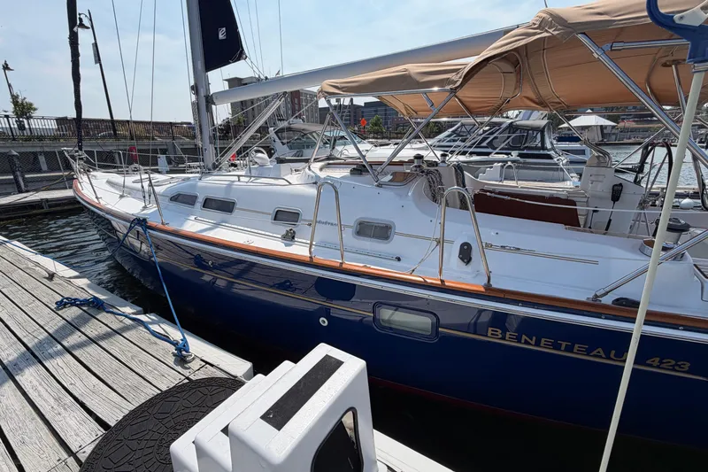 Slide: The Image of 2006 Beneteau 423 sailboat docked at marina, featuring sleek design and blue hull. - 2