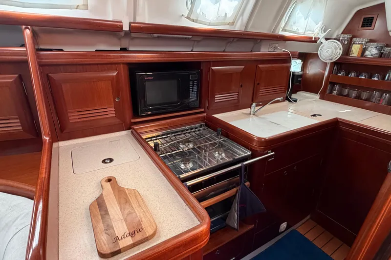 Slide: The Image of Luxurious 2006 Beneteau 423 yacht kitchen with wood cabinetry and modern appliances. - 31