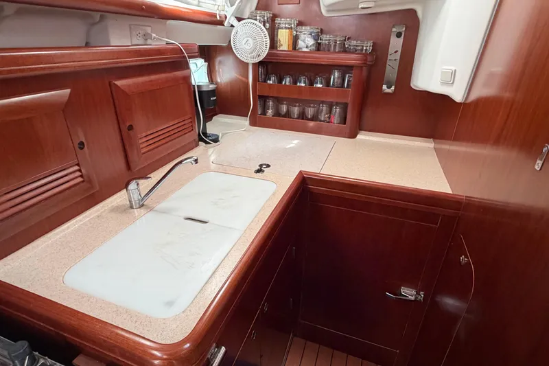 Slide: The Image of Luxurious 2006 Beneteau 423 yacht kitchen with wooden cabinetry and modern amenities. - 33