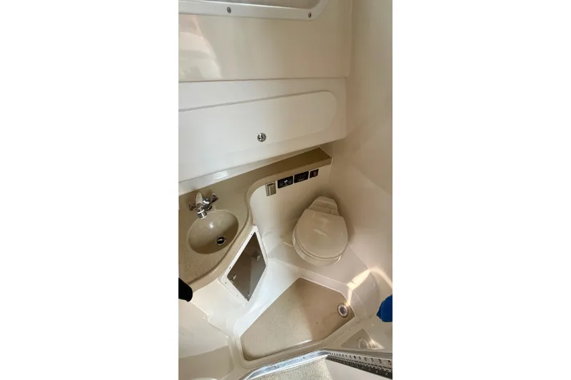 Slide: The Image of The image shows a compact boat bathroom with a sink and toilet. - 23
