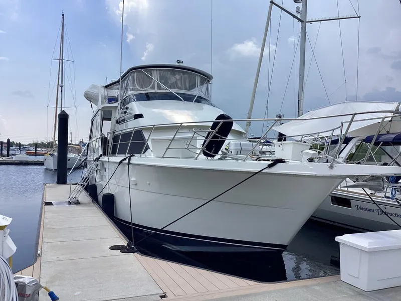 Slide: The Image of 1995 Hatteras 52 Motor Yacht docked at a marina, showcasing sleek design and spacious deck. - 5