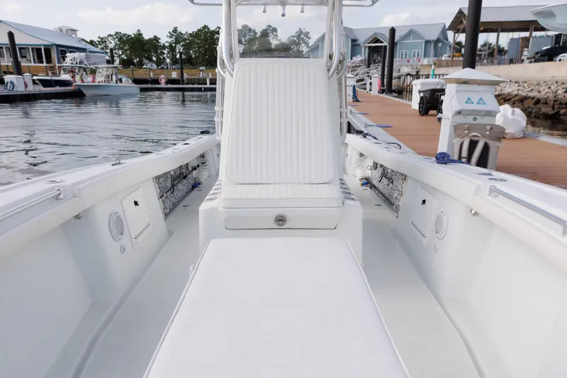 Slide: The Image of 2009 Yellowfin 29 Offshore boat interior at marina, showcasing seating and deck layout. - 14