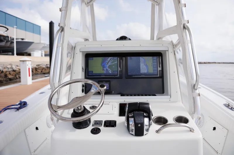 Slide: The Image of 2009 Yellowfin 29 Offshore boat dashboard with navigation screens and steering wheel. - 11