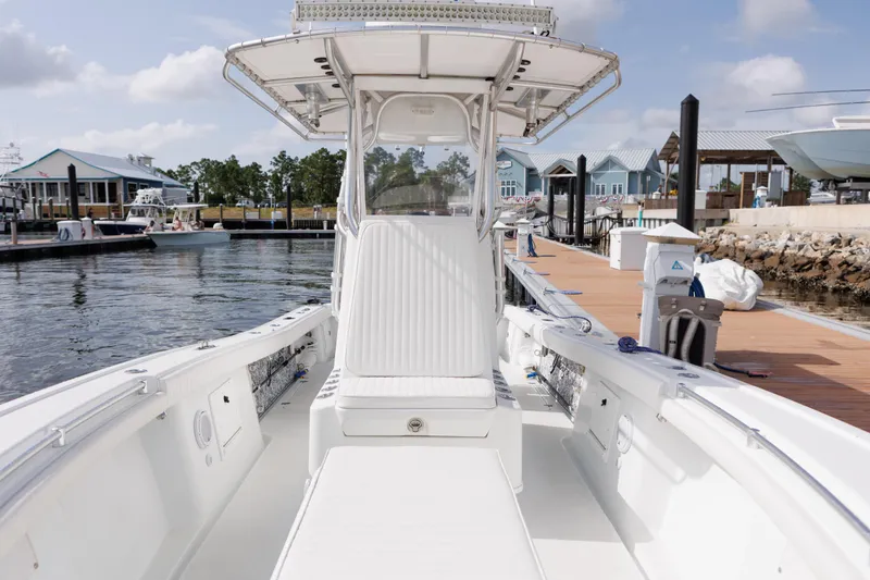 Slide: The Image of 2009 Yellowfin 29 Offshore boat docked at marina, showcasing spacious deck and seating. - 16