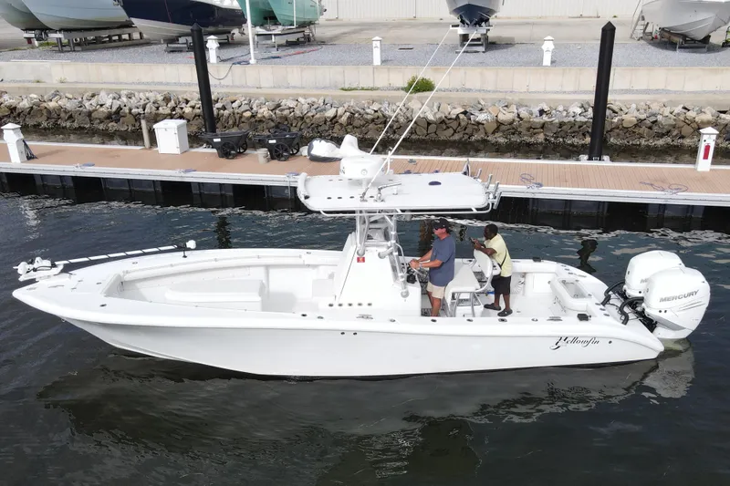 Slide: The Image of 2009 Yellowfin 29 Offshore boat docked, featuring dual Mercury engines and spacious deck. - 1