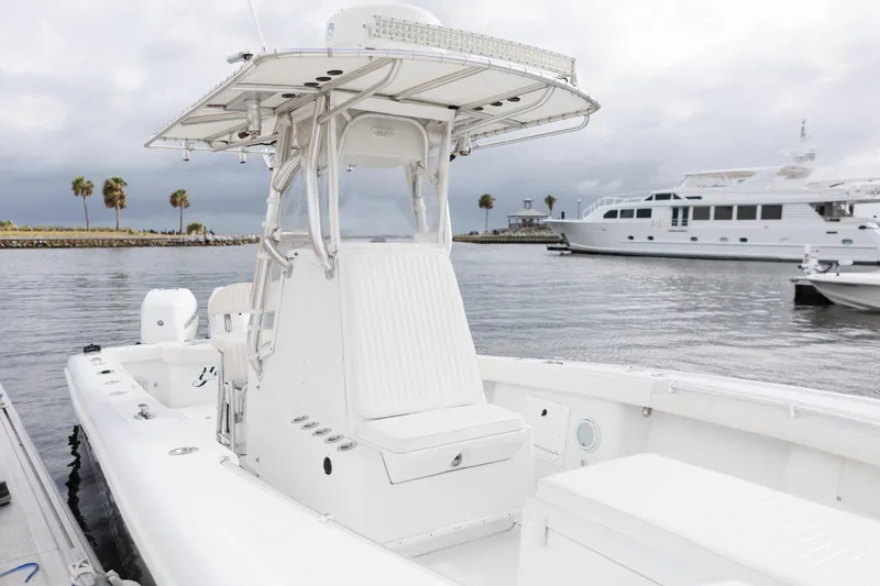 Slide: The Image of 2009 Yellowfin 29 Offshore boat docked, featuring sleek design and spacious seating. - 19