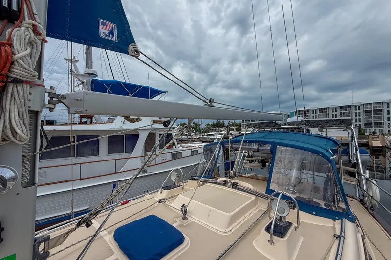 Slide: The Image of 2004 Island Packet 370 sailboat docked at marina under cloudy skies. - 27
