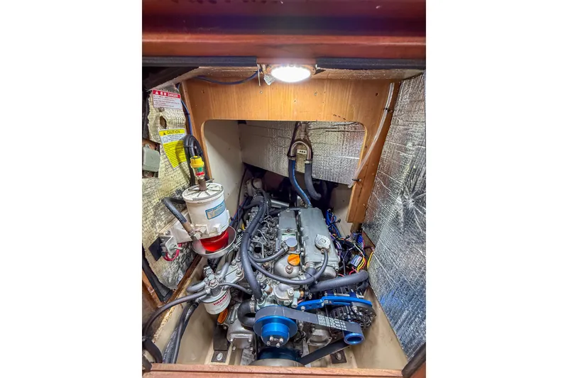 Slide: The Image of Engine compartment of a 2004 Island Packet 370 sailboat, showcasing mechanical components. - 32