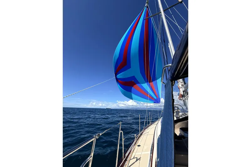 Slide: The Image of Sailing on a 2004 Island Packet 370 with vibrant blue and red spinnaker. - 39
