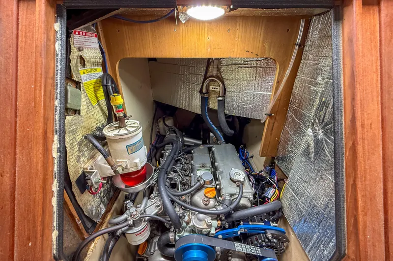 Slide: The Image of Engine compartment of a 2004 Island Packet 370 sailboat, showcasing mechanical components and insulation. - 33