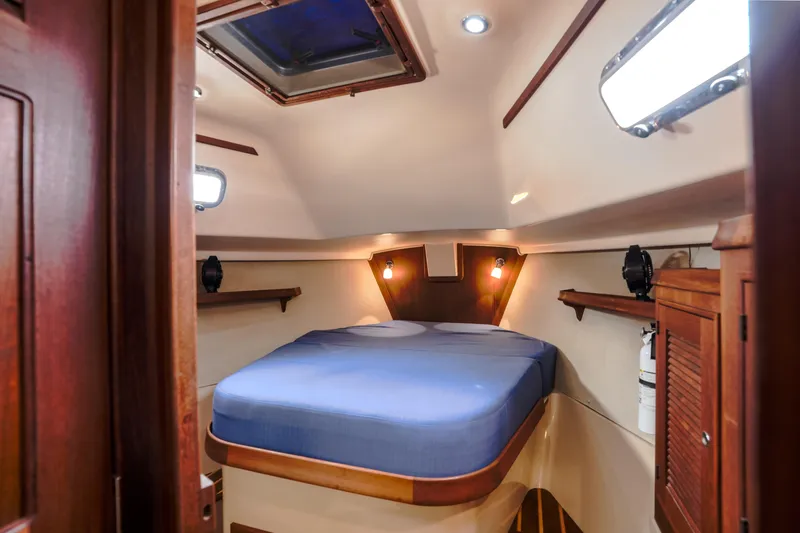 Slide: The Image of Cozy cabin interior of 2004 Island Packet 370 sailboat with blue bedding and wooden accents. - 14
