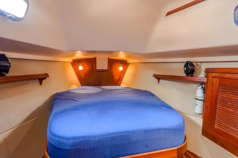 Slide: The Image of Cozy cabin interior of 2004 Island Packet 370 sailboat with blue bedding and wooden accents. - 15