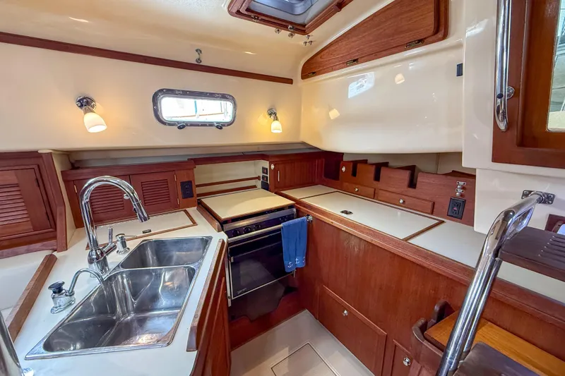 Slide: The Image of Luxurious 2004 Island Packet 370 yacht kitchen with wood cabinetry and stainless steel sink. - 9