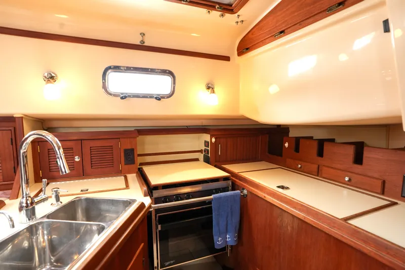 Slide: The Image of Interior of 2004 Island Packet 370 yacht kitchen with wooden cabinetry and stainless steel sink. - 10