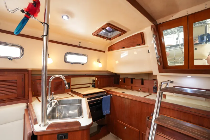 Slide: The Image of Interior of 2004 Island Packet 370 sailboat kitchen with wooden cabinetry and stainless steel sink. - 8