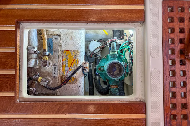 Slide: The Image of Engine compartment of a 2004 Island Packet 370 sailboat, showcasing mechanical components and wiring. - 36