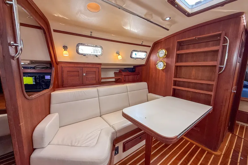 Slide: The Image of Interior of 2004 Island Packet 370 sailboat with cozy seating and wooden accents. - 7