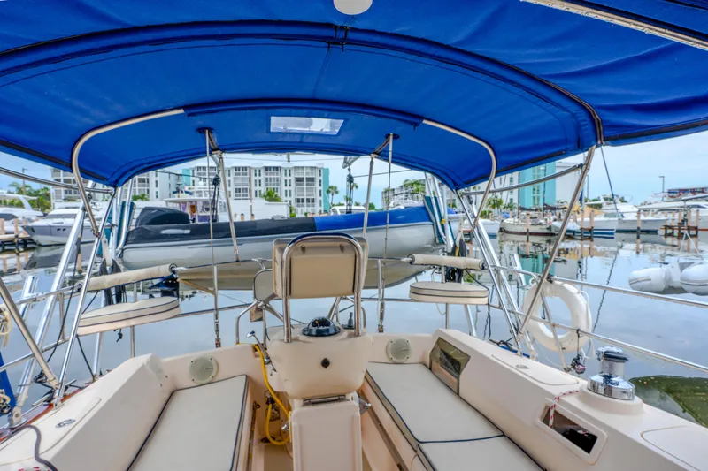 Slide: The Image of Cockpit view of 2004 Island Packet 370 sailboat with blue canopy in marina. - 28