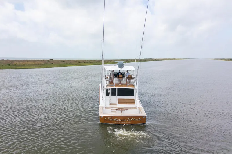 Slide: The Image of 2006 Viking 68 Convertible yacht cruising on a calm waterway under a cloudy sky. - 3