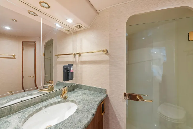 Slide: The Image of Luxurious bathroom in 2006 Viking 68 Convertible yacht with marble countertop and gold fixtures. - 34
