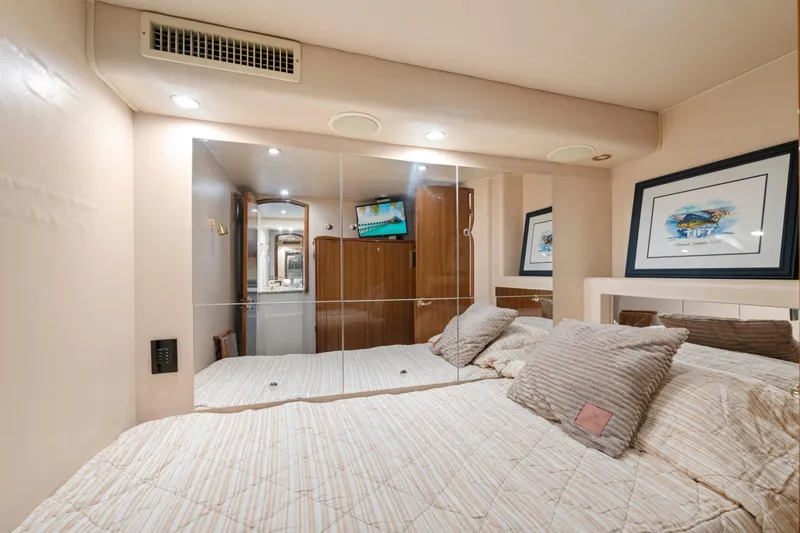 Slide: The Image of Luxurious bedroom interior of 2006 Viking 68 Convertible yacht with mirrored wall and cozy bedding. - 36