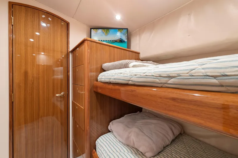 Slide: The Image of Interior of 2006 Viking 68 Convertible yacht with wooden bunk beds and storage. - 41