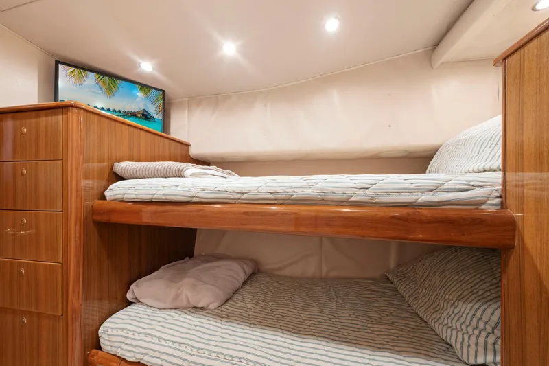 Slide: The Image of Interior of 2006 Viking 68 Convertible yacht with wooden bunk beds and cozy lighting. - 39