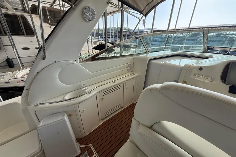 Slide: The Image of Interior of a 1999 Sea Ray 380 Sundancer yacht with white seating and wood flooring. - 6
