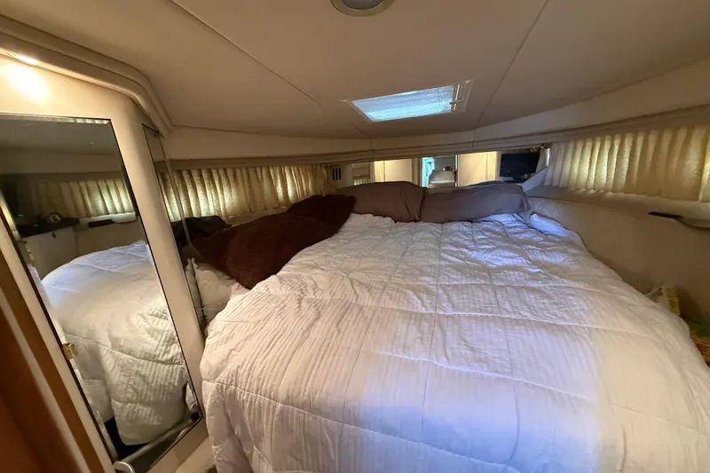 Slide: The Image of Cozy bedroom interior of 1999 Sea Ray 380 Sundancer yacht with plush bedding. - 18