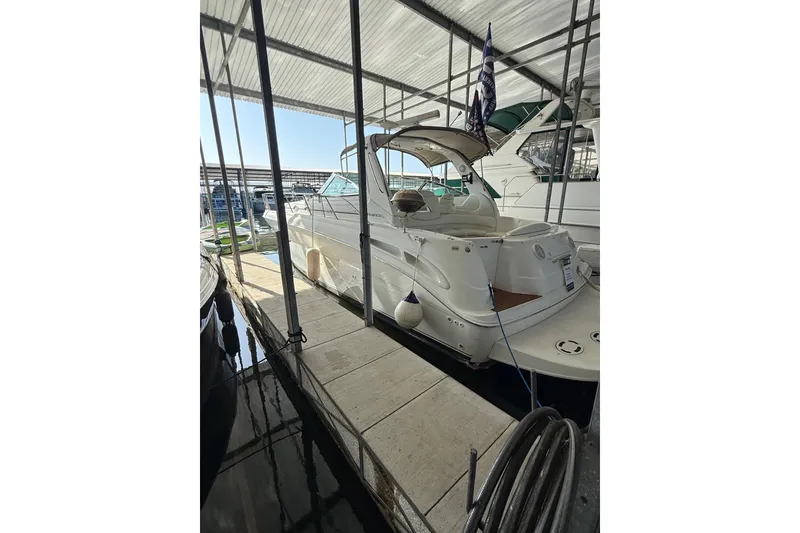 The Image of 1999 Sea Ray 380 Sundancer docked in a covered marina slip. - 1