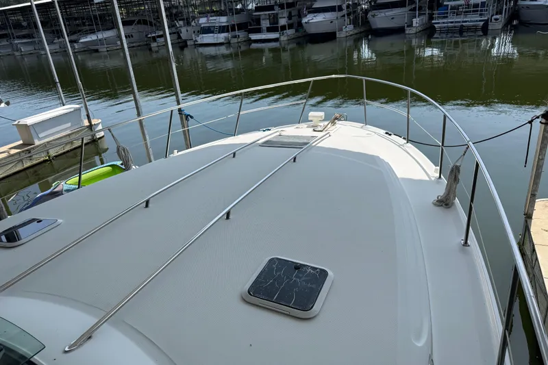 Slide: The Image of 1999 Sea Ray 380 Sundancer yacht docked at marina, view of bow and railing. - 10